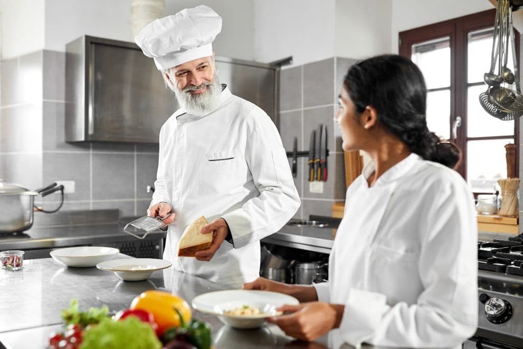 seorang sous chef sedang berbincang dengan staff dapur